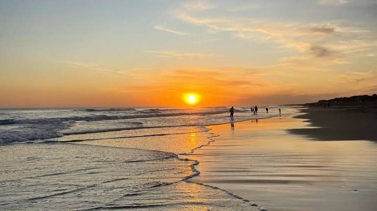 Amanecer en la playa de Arenas Verdes con el sol reflejado en la orilla
